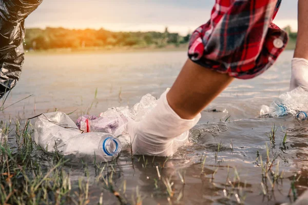 人类在河里捡一瓶塑料 保护环境不受水污染概念的影响 — 图库照片