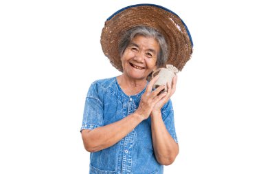 Mutlu yaşlı çiftçi kadın beyaz bir arka plan üzerinde bir para çantası tutan.