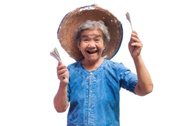 Mutlu yaşlı çiftçi kadın beyaz bir arka plan üzerinde bir para tutan.