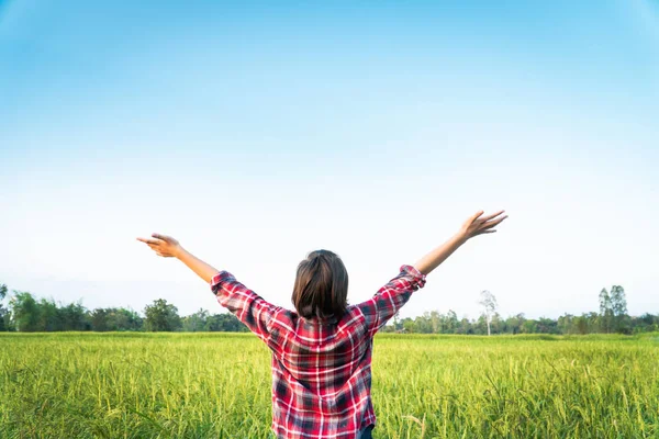 Happy moment young woman standing and open hands in rice field.