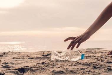 Plajda plastik şişe toplamak, çevreyi kurtarmak için gönüllü olmak..