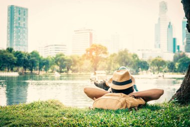 Şehirdeki ağacın altında dinlenen kadın.