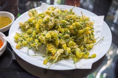 Sesbania çiçek kızarmış beyaz tabakta yumurta ve iki tür sos