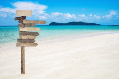 Ahşap okları tabela ile beyaz plaj güzel tropikal deniz üzerinde