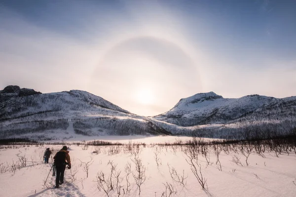 Mountaineers trekking on snow valley with sun halo natural in winter