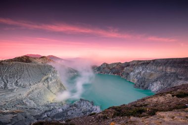 Etkin krater volkan dumanlı kükürt sabah renkli gökyüzü ile turkuaz gölde. Kawah Ijen'de, Doğu Java, Endonezya