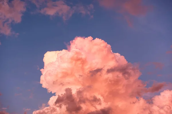 Colorful orange cloud cluster shiny in blue sky at twilight