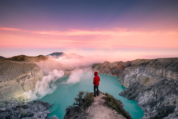 Renkli gökyüzü ile krater kenarında sabah saat ayakta adam. Kawah Ijen'de volkan, Doğu Java, Endonezya