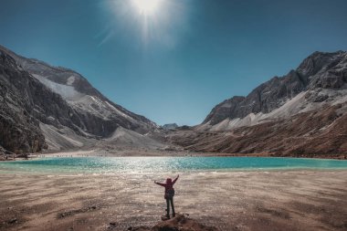 Turist kaldirsin kadar turkuaz göl ve dağ tepe üzerinde. Yading doğa rezerv