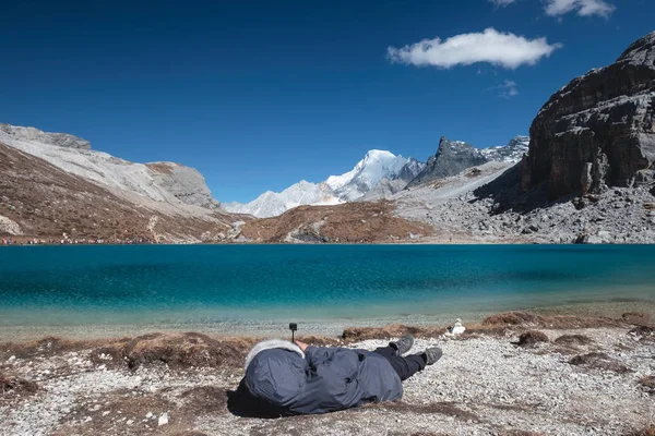 Young women sleep and relaxing on top of Milk Lake in peak valley at Yading nature reserve