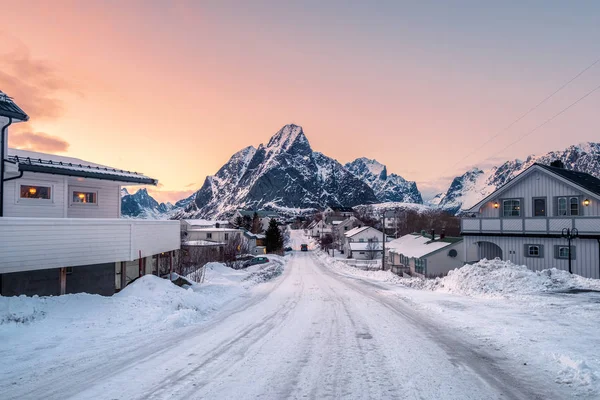 房屋覆盖雪与道路包围在山在日落时 Reine Lofoten — 图库照片