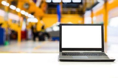 Bulanık sahne araç garaj ile bakım ve tamir ile beyaz masa üstünde laptop