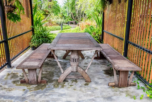 Dining wood table in lush garden