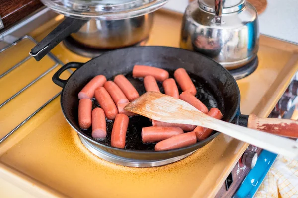 Cuisiner le petit déjeuner avec des saucisses dans une poêle à frire avec du bois flip — Photo