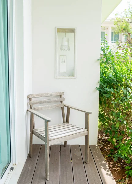 Sedia in legno su pavimento in legno e cavità parete bianca — Foto Stock