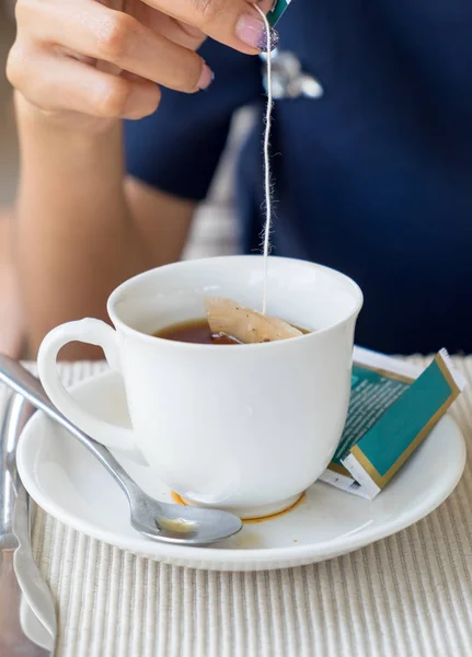 Çay Kupası daldırma el kadınlar — Stok fotoğraf