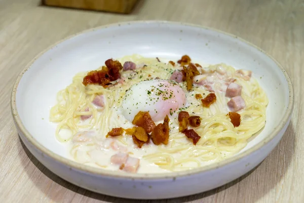 Spagetti Carbonara fehér mártással, tetején sonka és szalonna és tojás bo — Stock Fotó