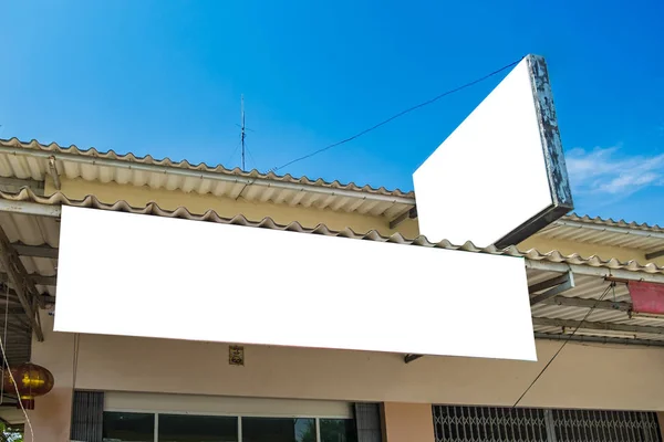 House store with white signboard and sky