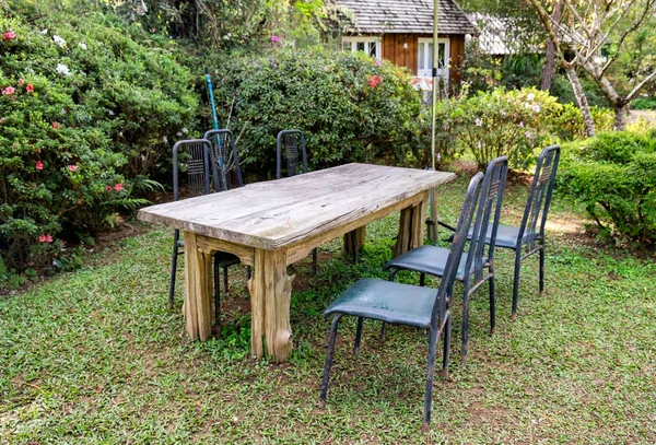 Drewnianych stół z krzesłami w zacienionym ogrodzie — Zdjęcie stockowe