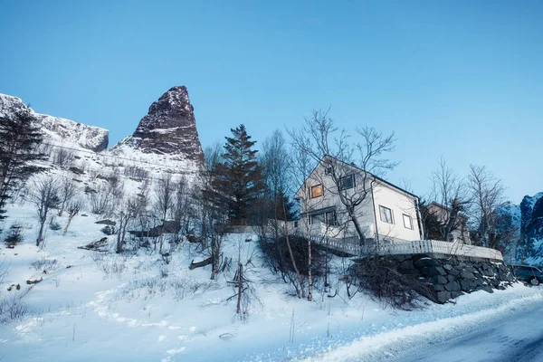 White scandinavian house with famous mountain in winter at Lofot