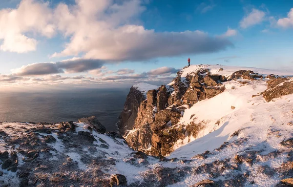 Gün batımında kışın rock dağ tepe üzerinde duran dağcı
