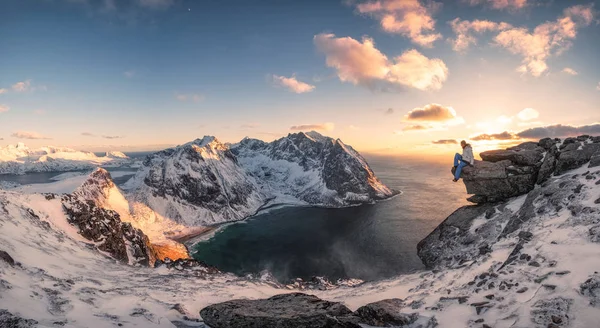 Панорама альпиниста, сидящего на скале на вершине арки — стоковое фото