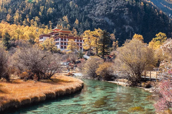 Chong Gu tempel op herfst heuvel met emerald rivier op Yading — Stockfoto