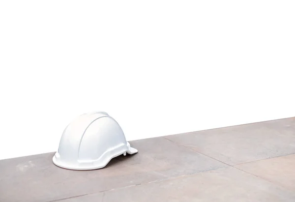 Casco rigido di sicurezza bianco su pavimento di cemento su sfondo — Foto Stock