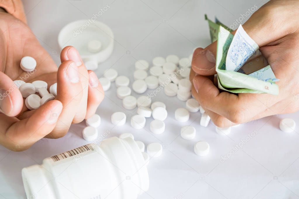 Hands holding analgesic medicine scattered
