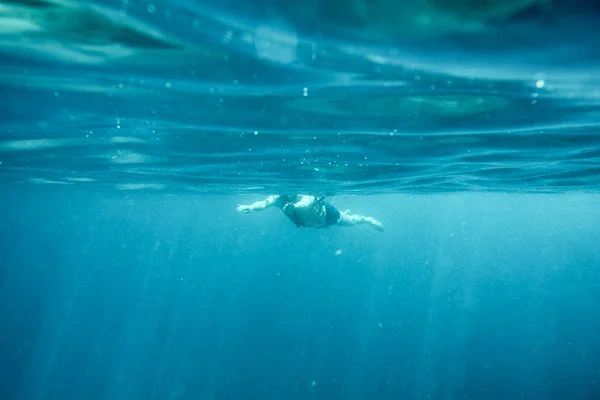 Man in de blauwe oceaan zwemmen — Stockfoto