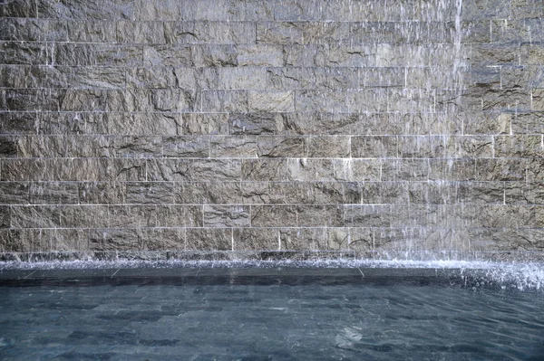 Каменный серый фонтан в пруду — стоковое фото