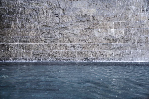 Каменный серый фонтан в пруду — стоковое фото