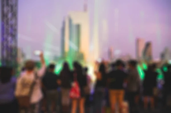 Blurred scene people seeing show of laser light with fountain ev — Stock Photo, Image