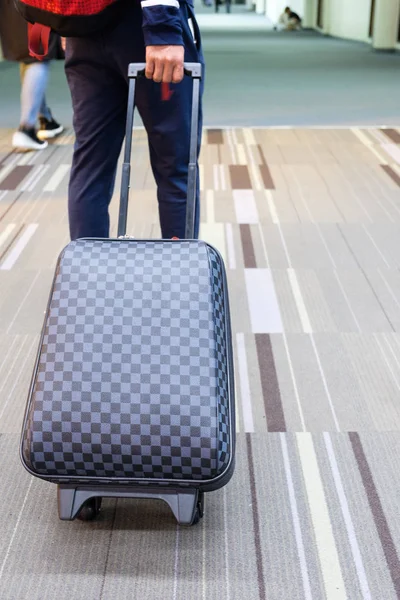 Junger Reisender zerrt Gepäck am Flughafen — Stockfoto