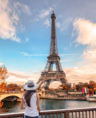 Genç kadın görünümünü Eyfel Kulesi Paris adlı sonbaharda arıyor.