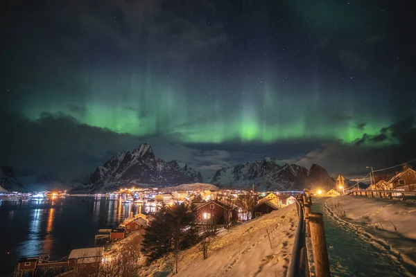 Aurora boreal sobre a luz da aldeia escandinava brilhando em winte — Fotografia de Stock