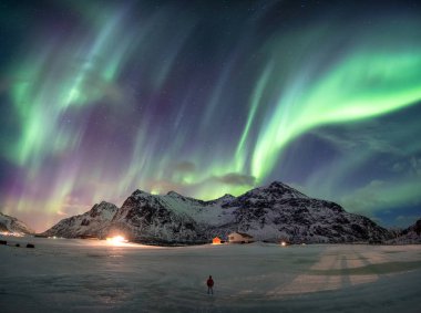 Fantastik Aurora borealis adam ayakta ile karlı dağ üzerinde