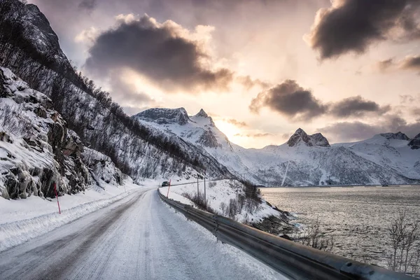 Polna droga w dolinie śniegu na wybrzeżu o zachodzie słońca — Zdjęcie stockowe