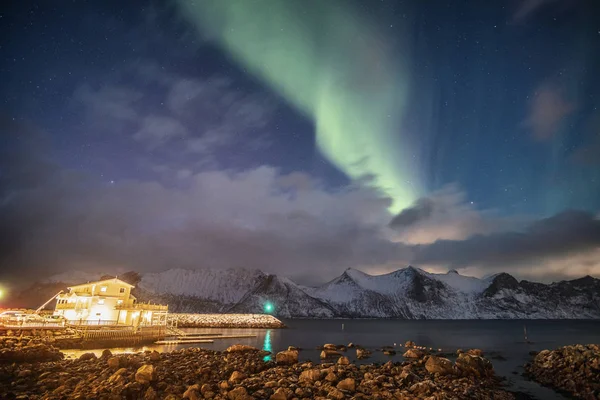 Aurora boreal en la montaña nevada con casa de luz —  Fotos de Stock