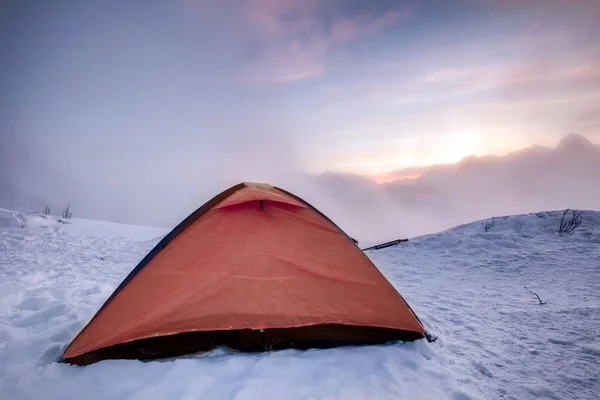 Camping orange tent on snowy hill in morning — Stock Photo, Image