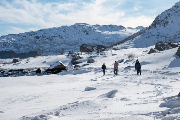 Туристы прогуливаются по снежному холму на солнце — стоковое фото