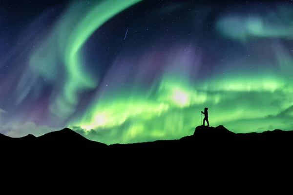 Adam dağ Kuzey ışıkları patlama ile hiking — Stok fotoğraf