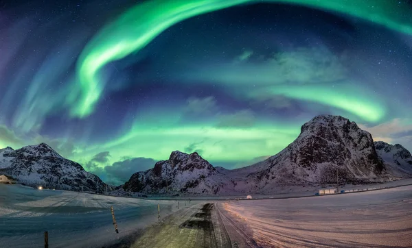 Polární záře výbuchu na zasněžené pohoří — Stock fotografie