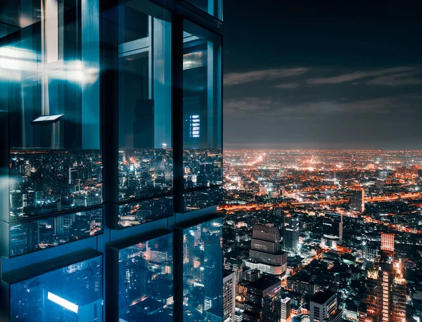 Glass window with glowing crowded city — Stock Photo, Image