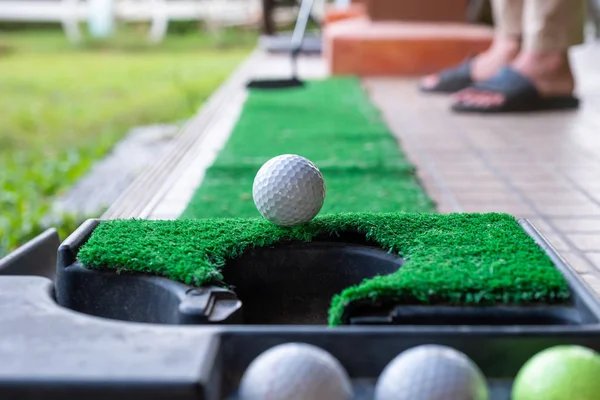 Golfer putting a golf ball into the edge hole — Stock Photo, Image