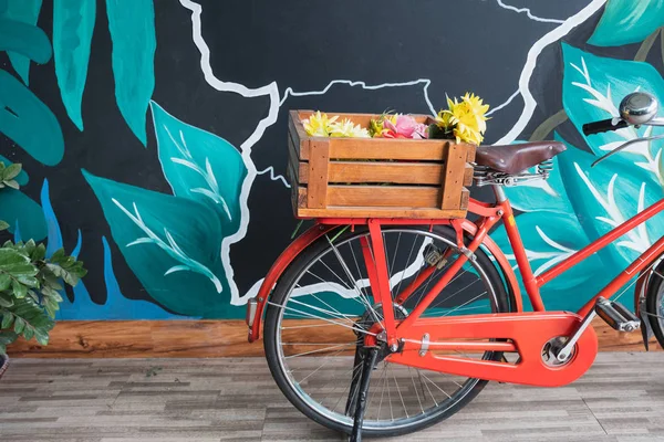 Винтажный красный велосипед с цветами в деревянной корзине — стоковое фото