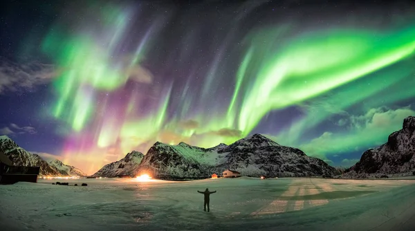 Aurora boreal (auroras boreales) sobre la montaña con una persona — Foto de Stock