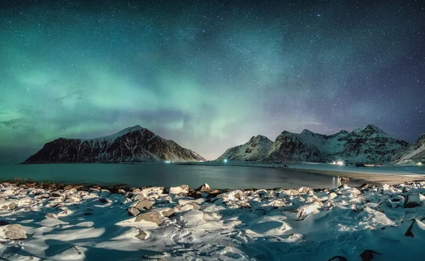 눈 덮인 coastl 있는 산맥 너머의 별 들과 함께 하는 오로라 — 스톡 사진