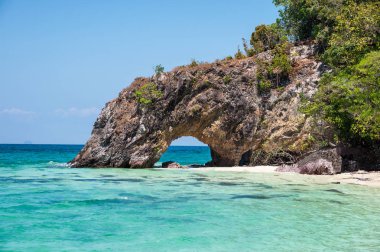 Turkuaz deniz ve plaj üzerinde doğal taş kemer