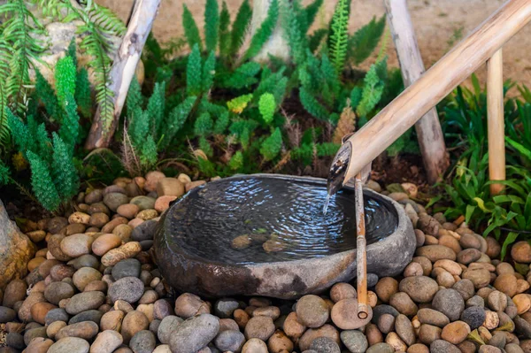 Бамбуковая струящаяся вода на украшении каменного бассейна — стоковое фото